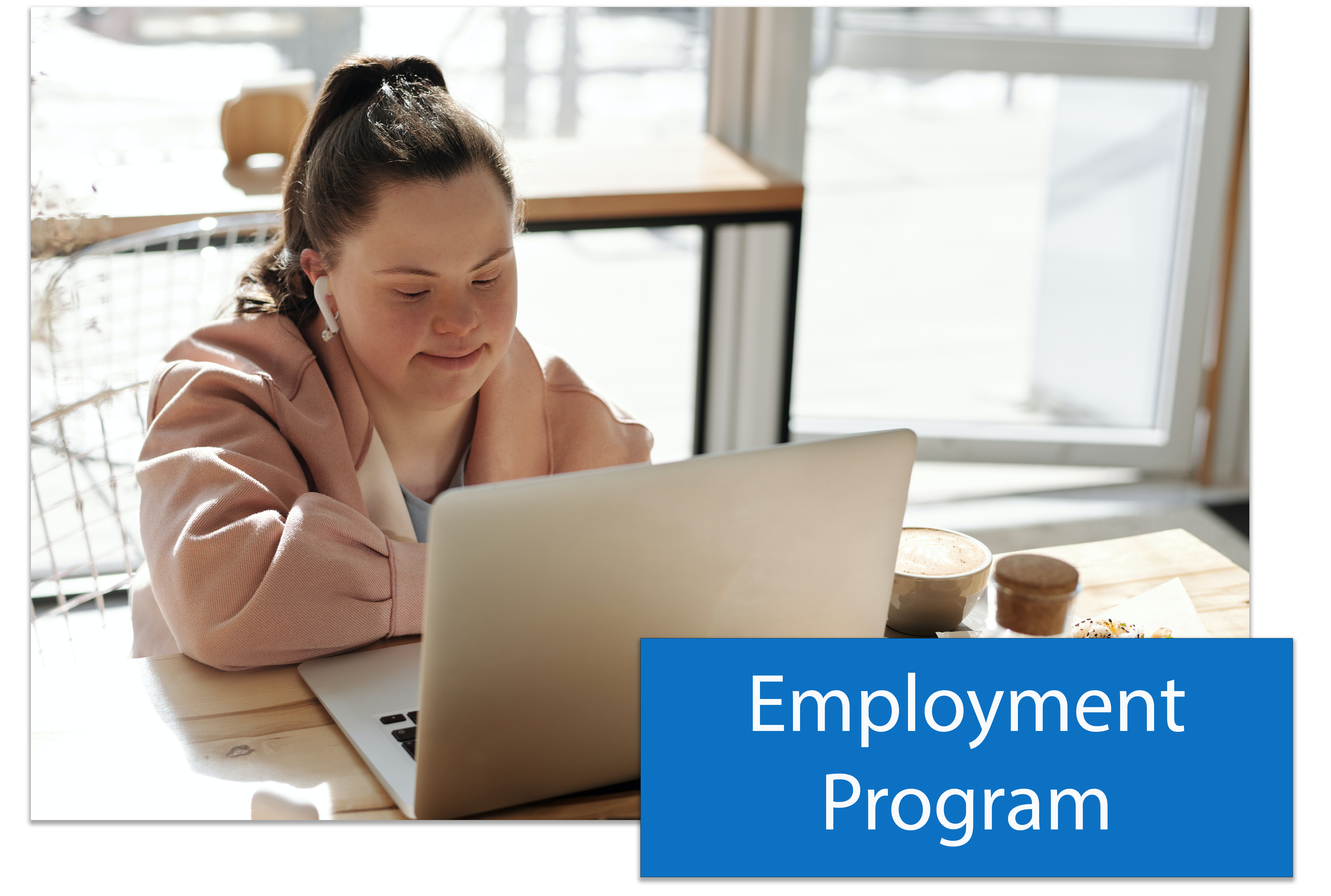 A button that says Employment Program placed in the lower right hand corner of an image of a woman with Downs Syndrome working on a laptop at a desk.