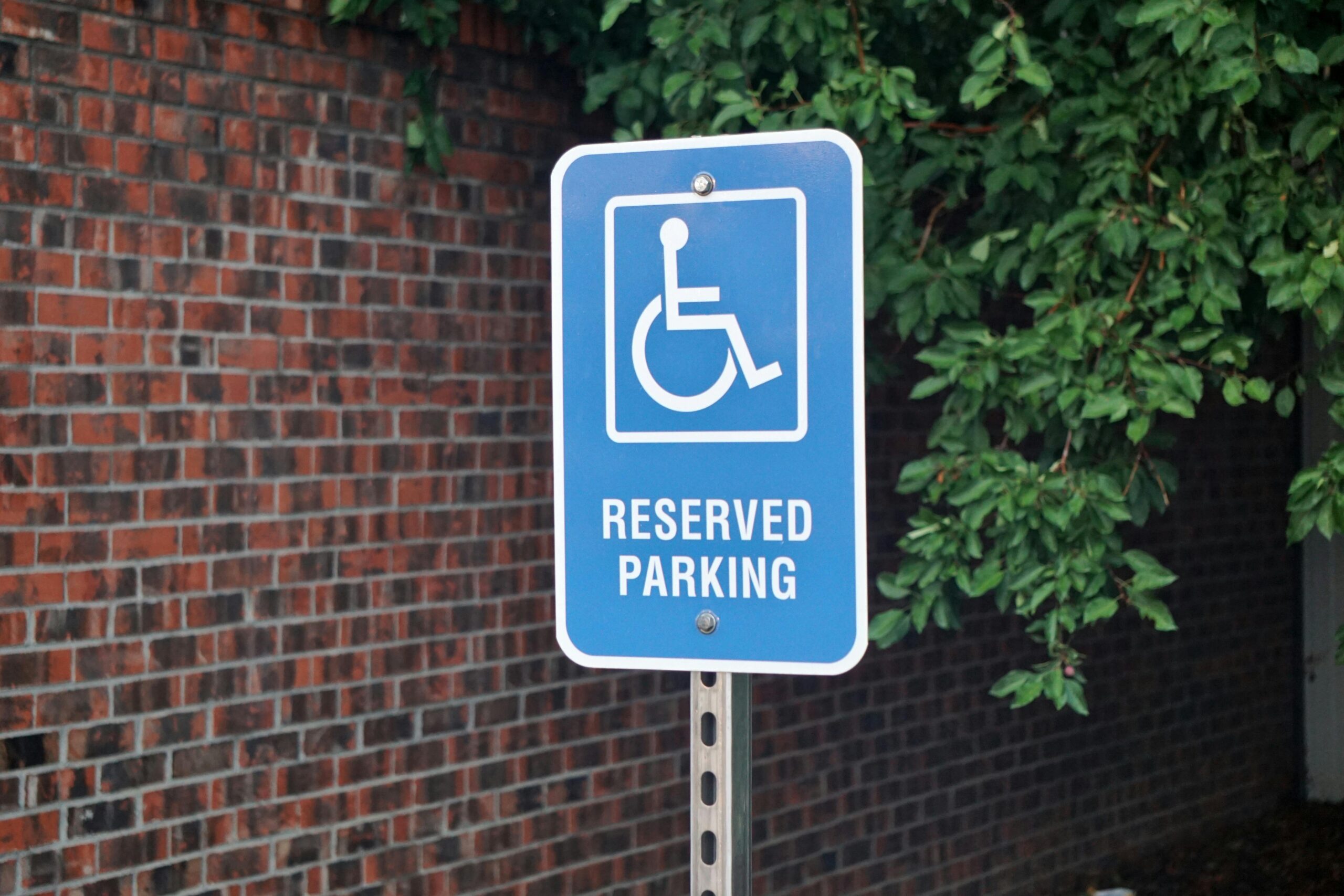 A reserved parking sign shows the icon for accessible parking